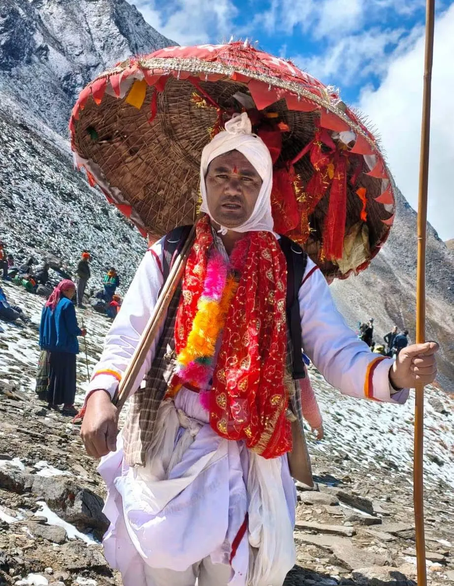A pilgrim carrying a chhatoli, the ritual umbrella woven from ringal, decorated for the Nanda Devi Raj Jat
