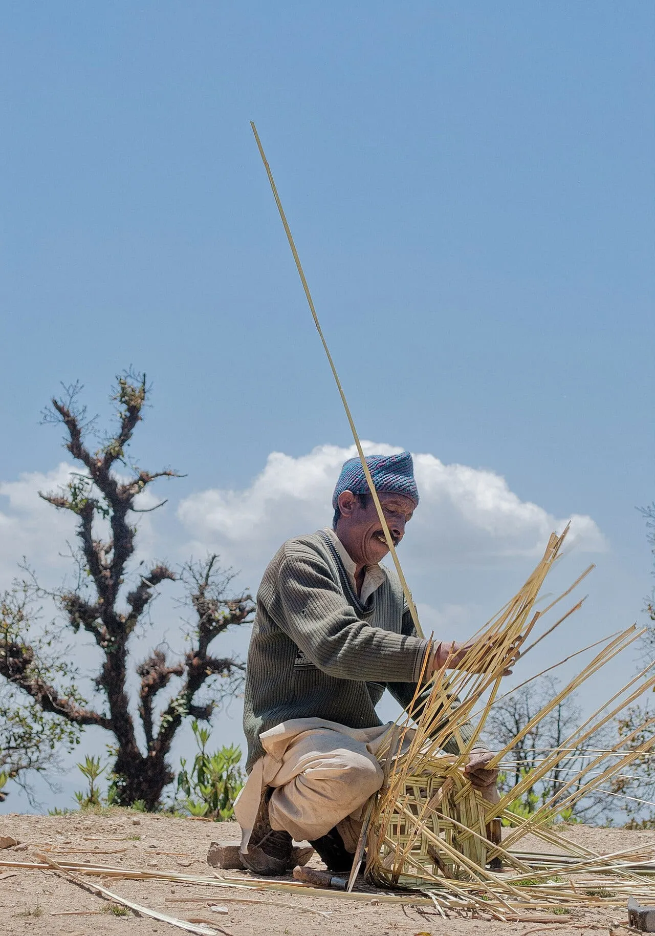 A weaver splitting ringal cane for a basket in Chamoli district
