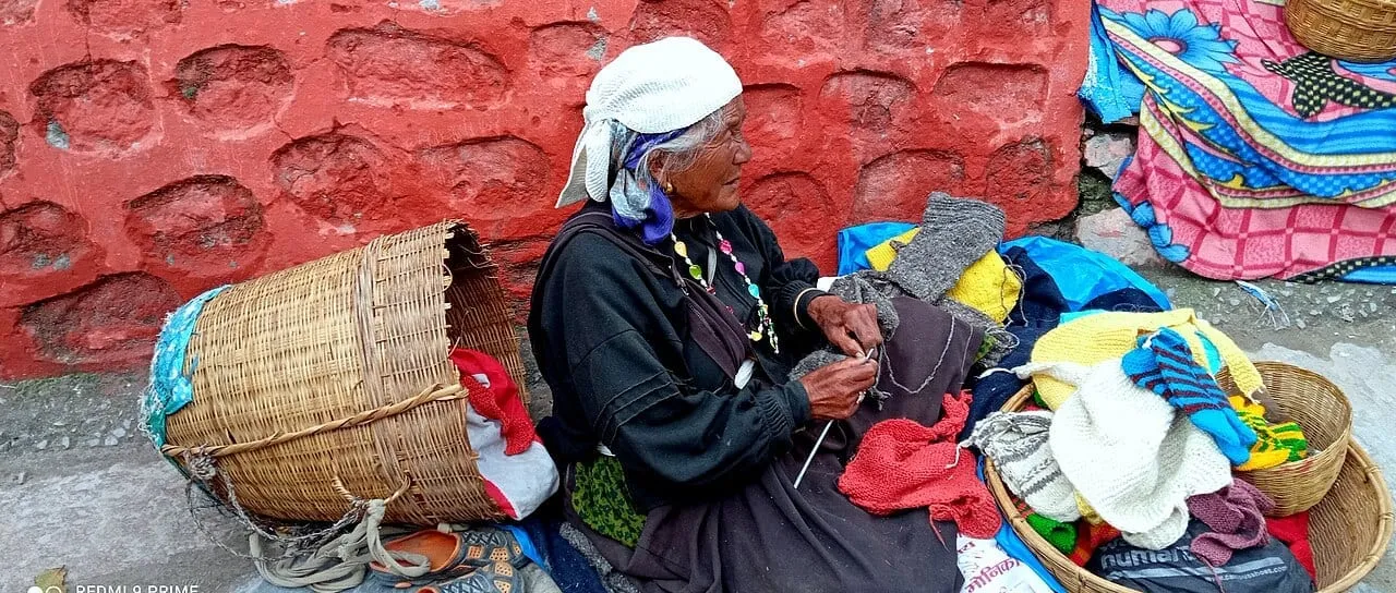 An elderly Bhotia woman weaving among her woollens in Mana village